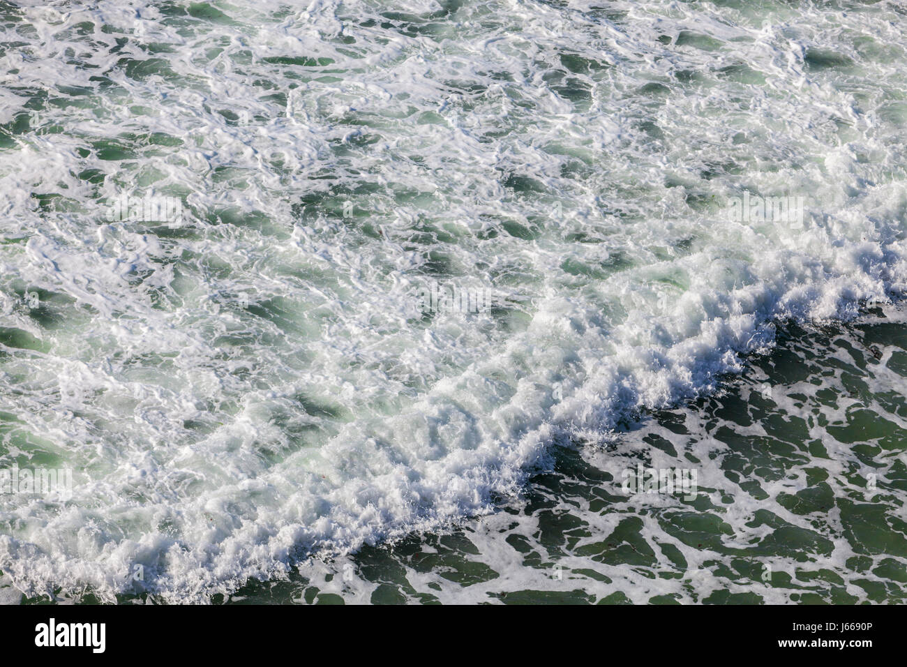 Aerial view of the foamy ocean surface wiht a crashing wave Stock Photo ...