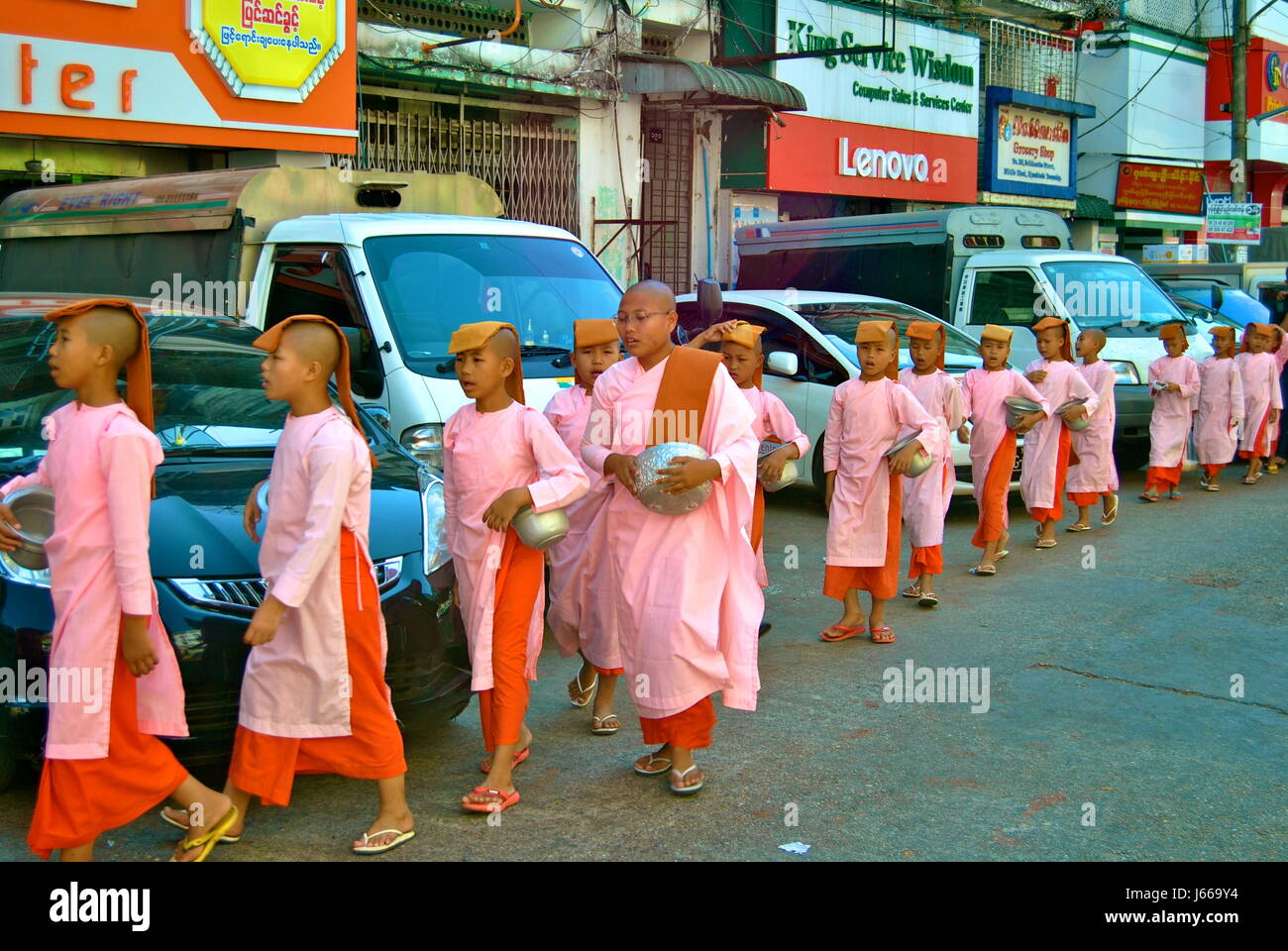 Young monks, collecting alms, Yangon, Myanmar Stock Photo