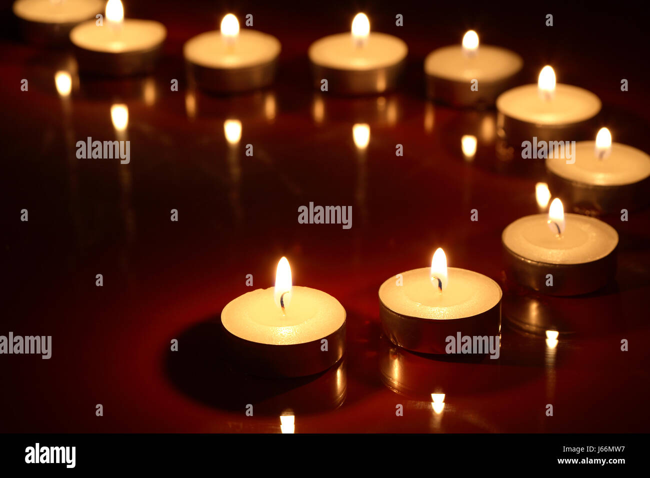 Set of lighting candles in a row on dark background Stock Photo - Alamy