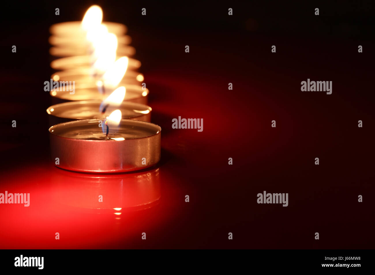 Set of lighting candles in a row on dark background with free space for ...