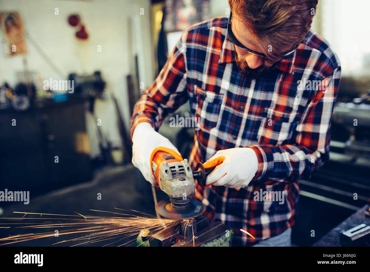 Young manual worker working with grinder Stock Photo