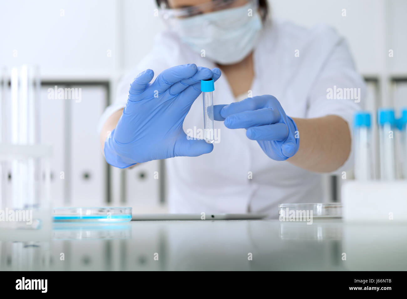 Close up of scientific research hands with clear solution in laboratory ...