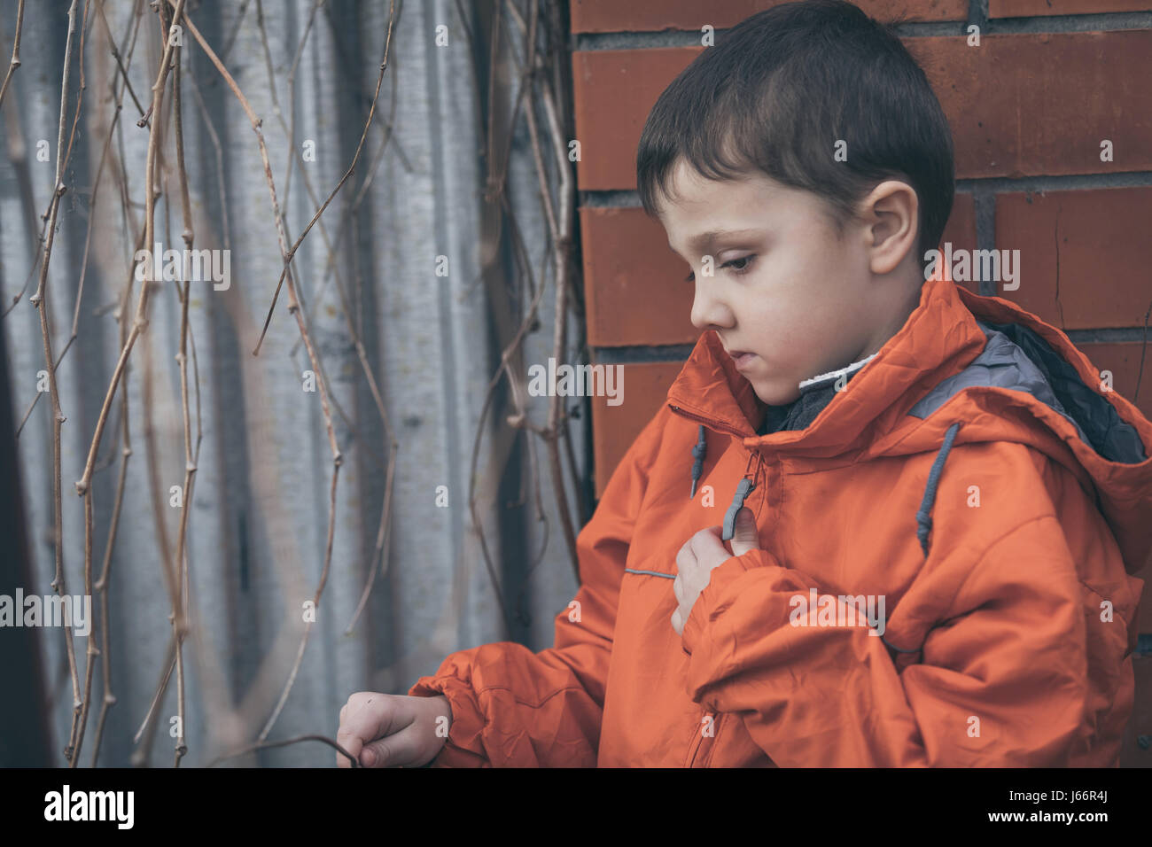 Portrait of sad little boy outdoors at the day time. Concept of dreary ...