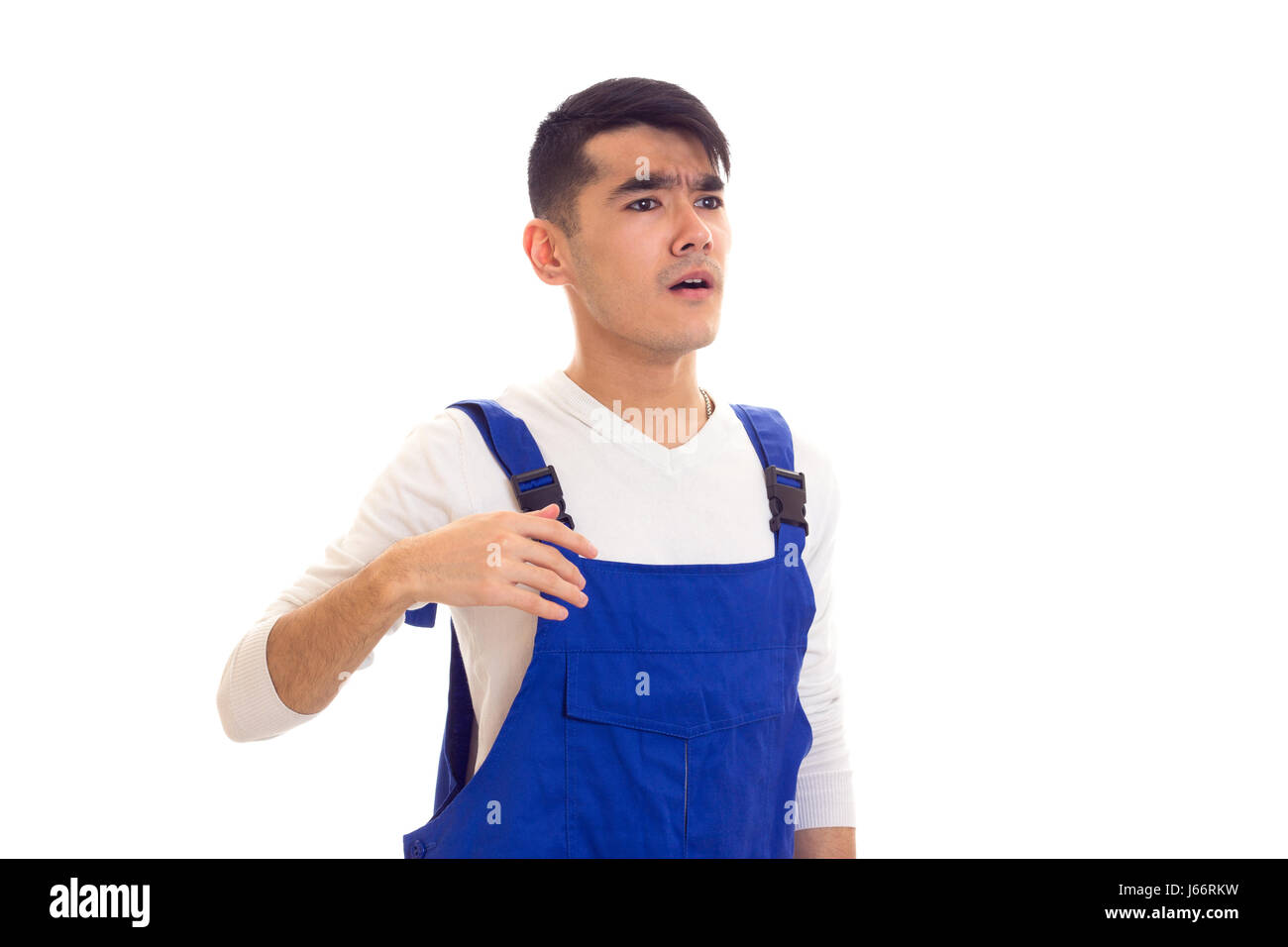 Young man in blue overall looking in a distance Stock Photo