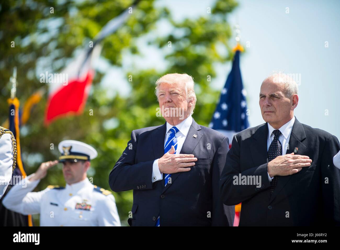 U.S. President Donald Trump and Homeland Security Secretary John Kelly stand for the national anthem during the 136th Coast Guard Academy graduating class May 17, 2017 in New London, Connecticut. Stock Photo
