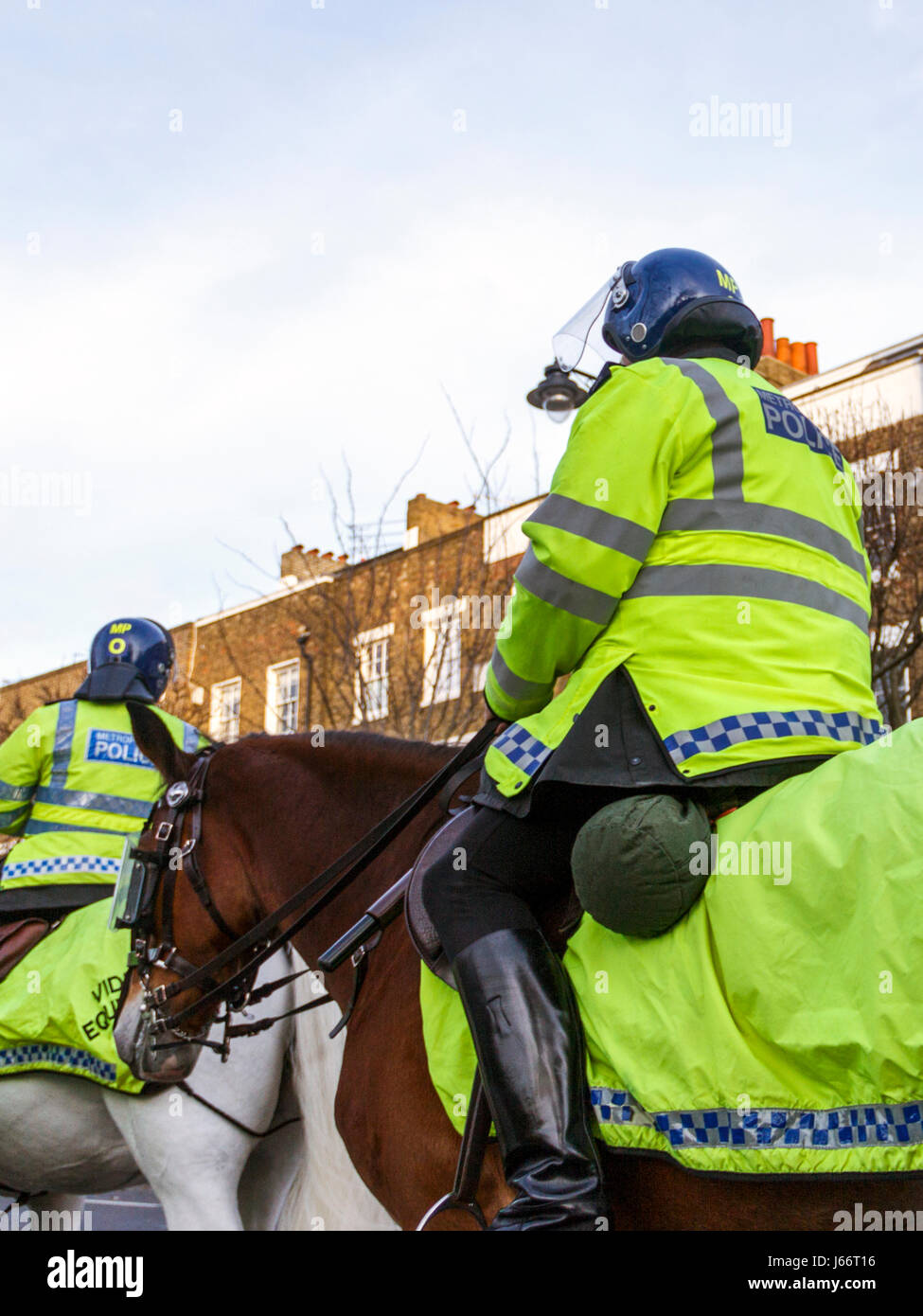 Mounted police officers in yellow high-visibility uniform on match day, Islington, London, UK Stock Photo