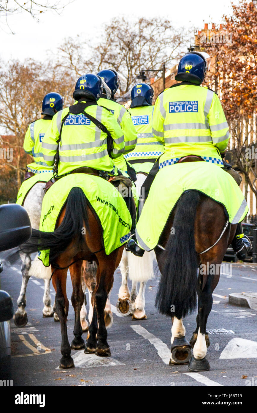 Mounted police officers in yellow high-visibility uniform on match day, Islington, London, UK Stock Photo