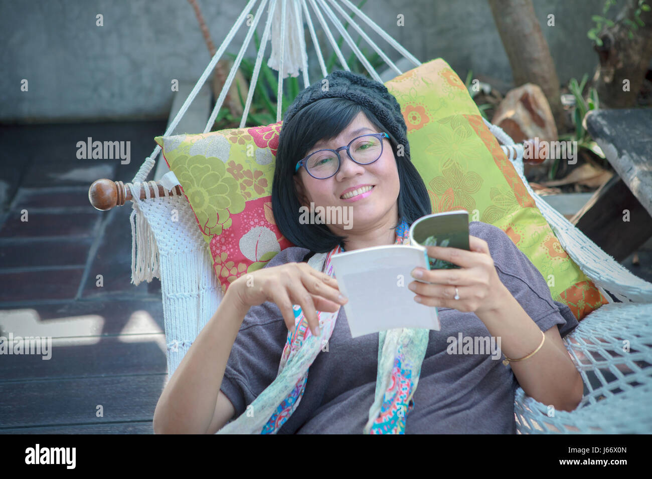 portrait of beautiful asian woman relaxing time reading book on cradle happiness emoton with smiling face Stock Photo