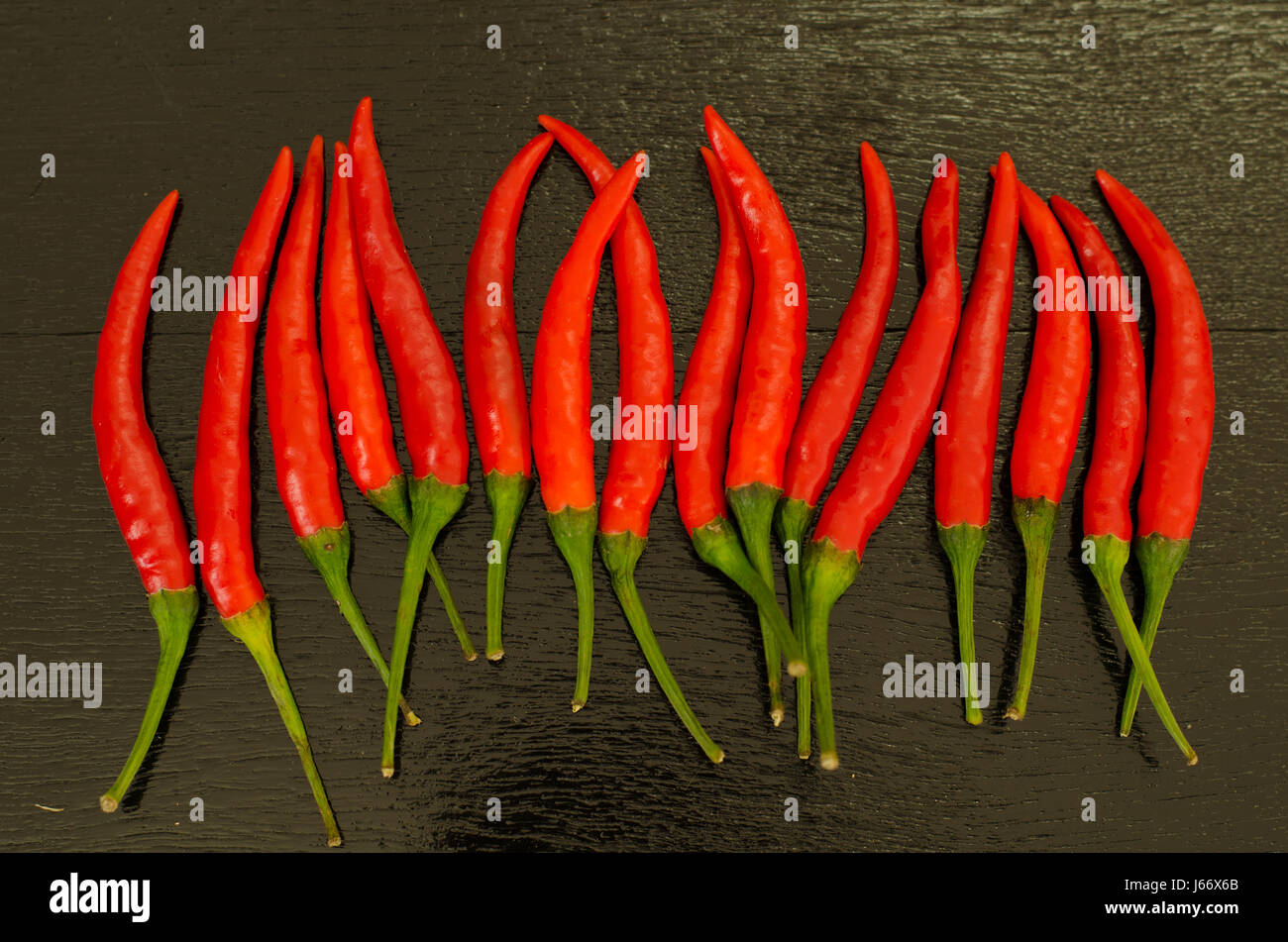 Red hot chili peppers on black wooden background Stock Photo - Alamy