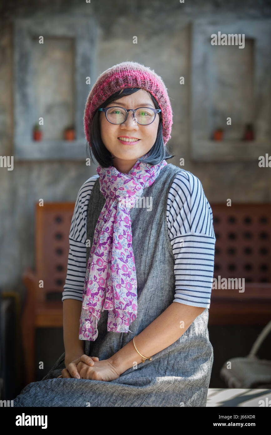 portrait of 40s years asian woman wearing wool hood and silk scarf toothy smiling with happiness emotion Stock Photo