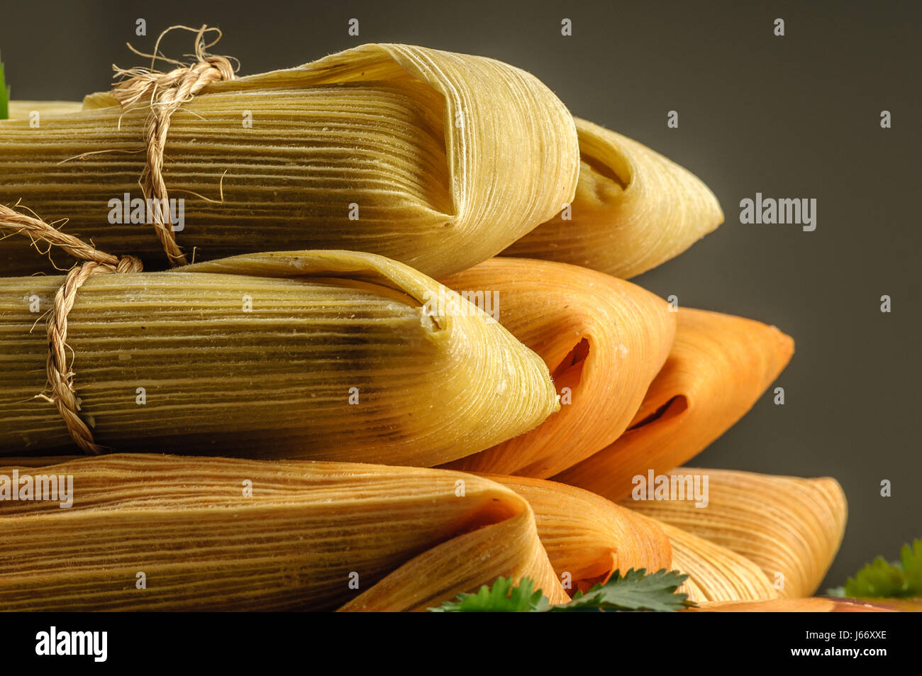 Tamales, Mexican dish made with corn dough, chicken and chili, wrapped with a corn leaf Stock Photo