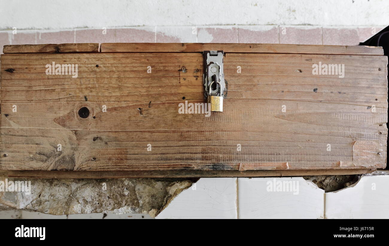 Padlocked wood box placed on white tile shelf protruding from the wall of a shed used as bicycle parking for the local caretakers of the Tham Jang or  Stock Photo
