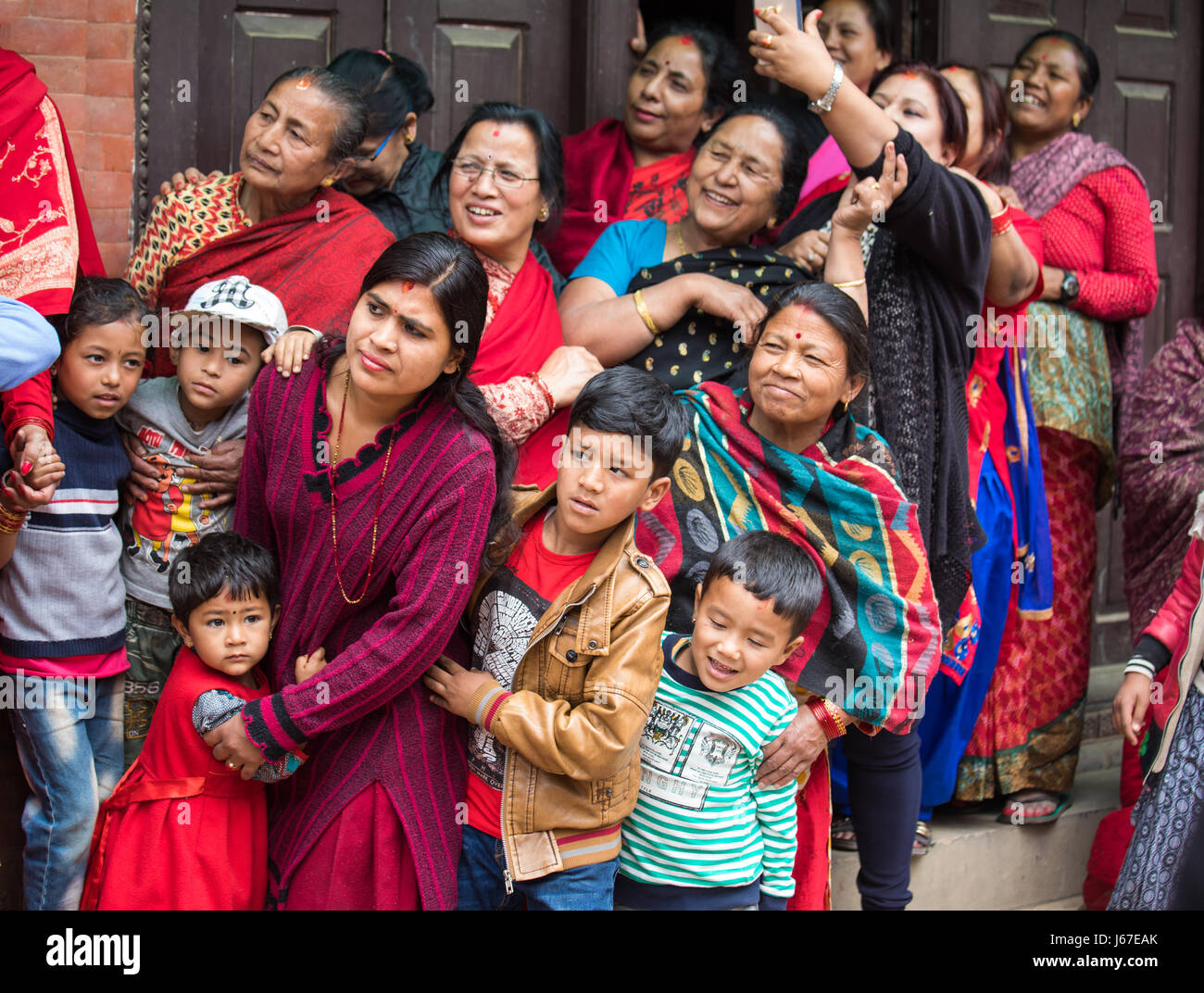 Kathmandu, Nepal Apr 15, 2016 Families in traditional Nepalese clothing watching a passing