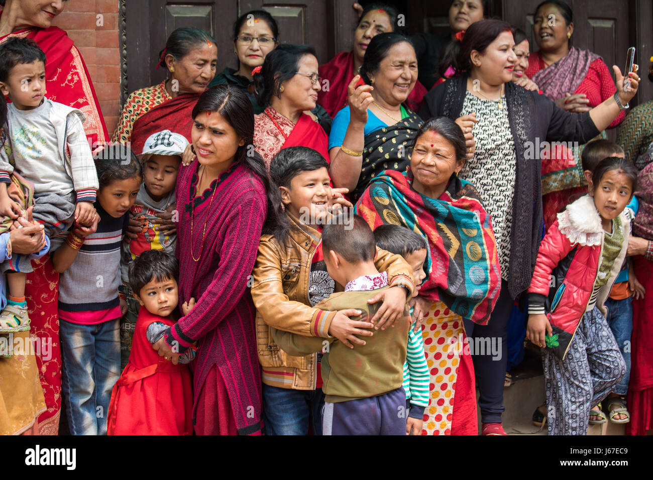 Kathmandu, Nepal Apr 15, 2016 Families in traditional Nepalese clothing watching a passing