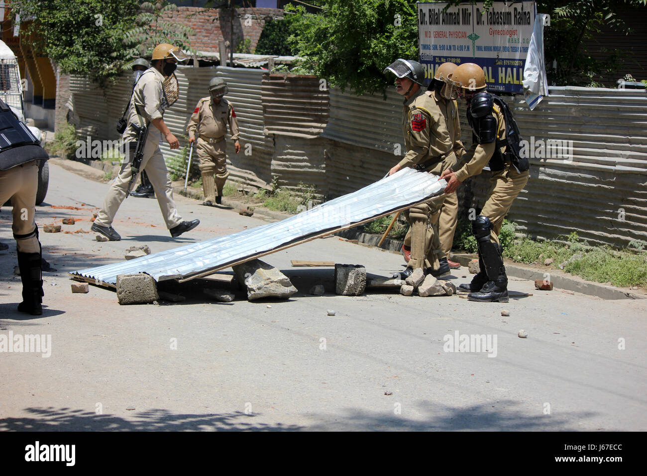 Anantnag, India. 19th May, 2017. Policeman Clears roads blocked by Stone pelters during clashes with Security forces after Friday Prayers in Anantnag. Credit: Muneeb Ul Islam/Pacific Press/Alamy Live News Stock Photo