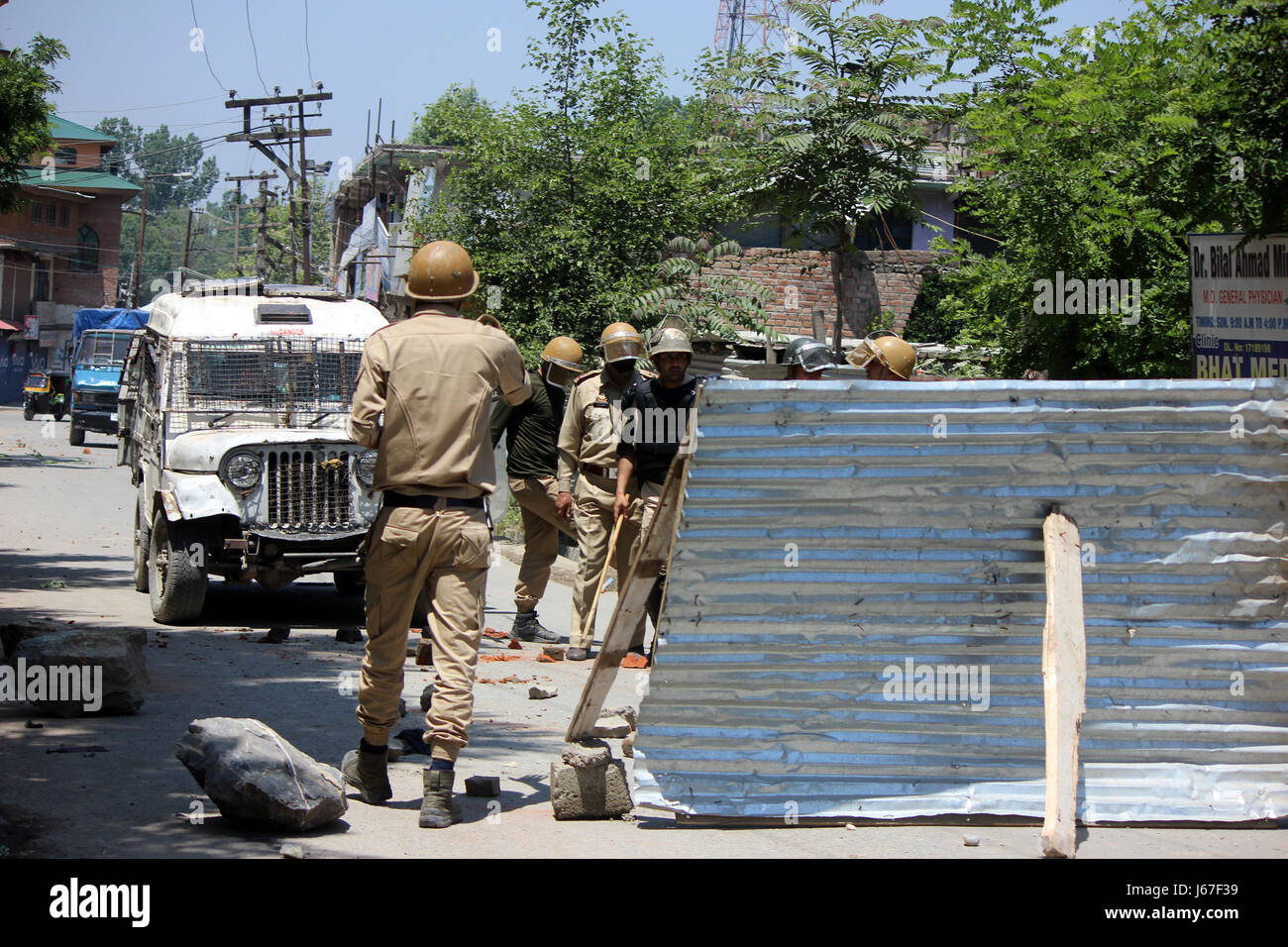 Anantnag, India. 19th May, 2017. Policeman Clears roads blocked by Stone pelters during clashes with Security forces after Friday Prayers in Anantnag. Credit: Muneeb Ul Islam/Pacific Press/Alamy Live News Stock Photo