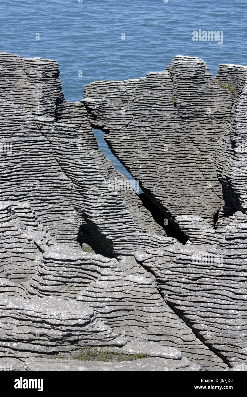 rock new zealand grey gray blue stone waves rock new zealand layers stratified Stock Photo