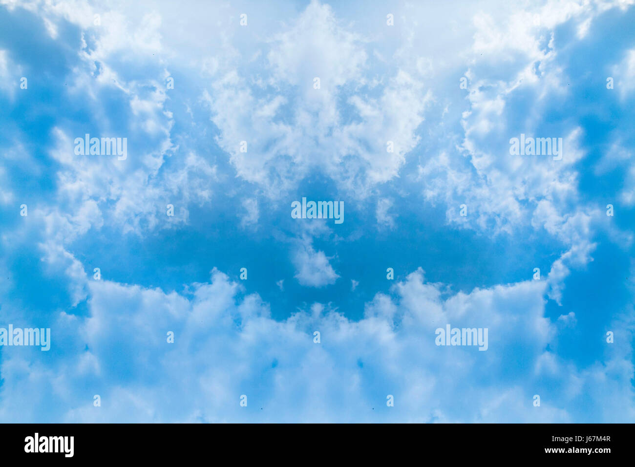 Symmetrical cloud patterns reveal a gap beyond which there is bright blue sky Stock Photo