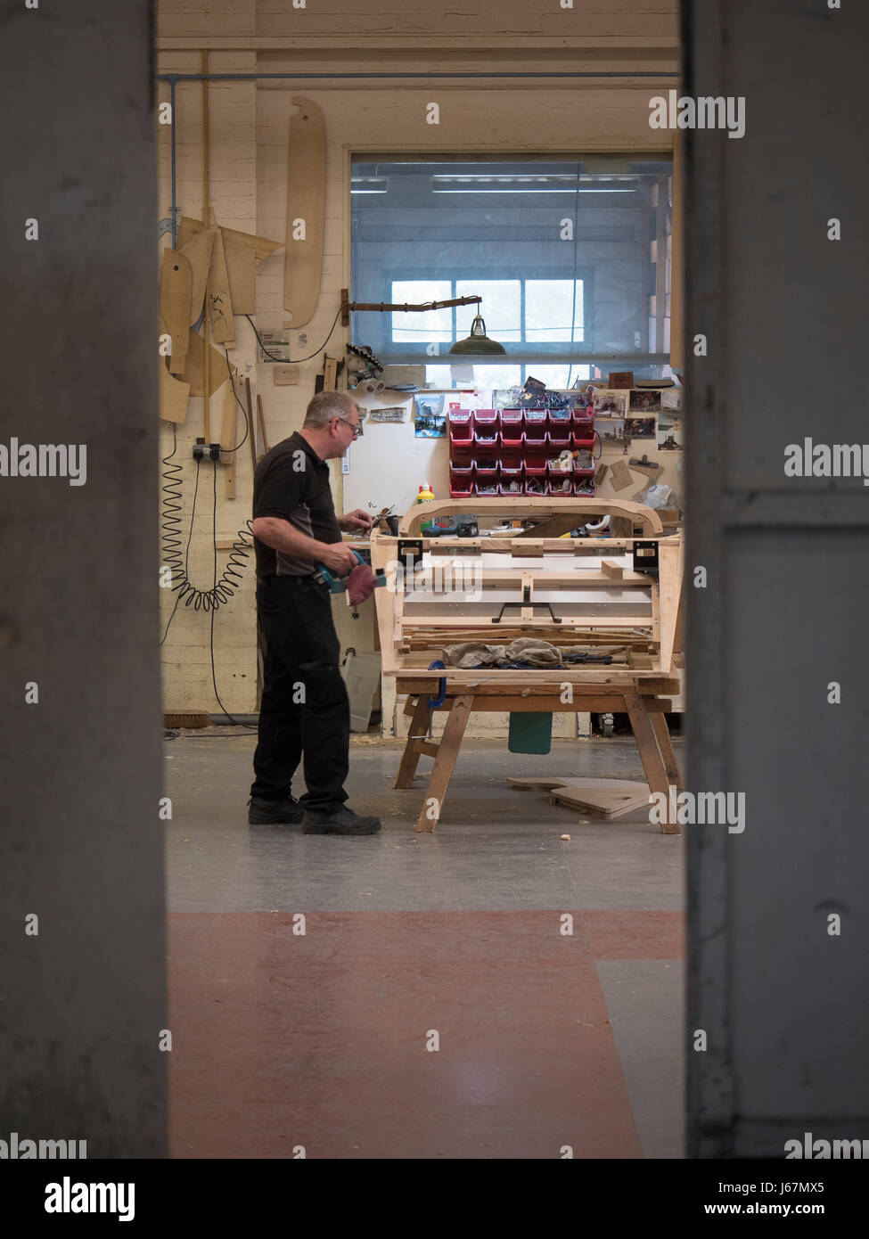 Ash wood is bent by craftsmen into frame parts for each custom made Morgan automobile at the Malvern, England factory. Stock Photo