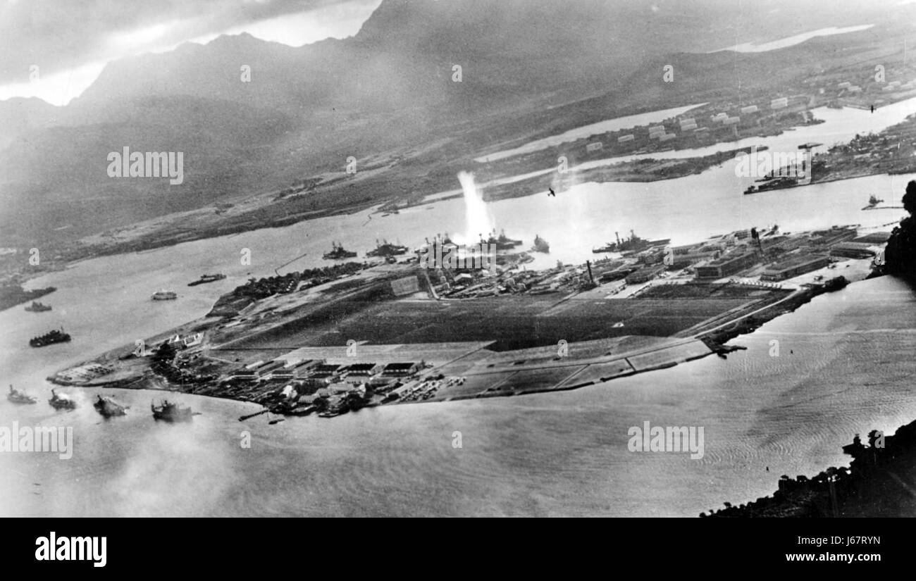PEARL HARBOUR 7v December 1941. Photo from a Japanese aircraft showing two attacking fighter planes from the first wave. The explosion at centre is a torpedo strike on the USS West Virginia. The Arizona is the second ship from the left. Stock Photo