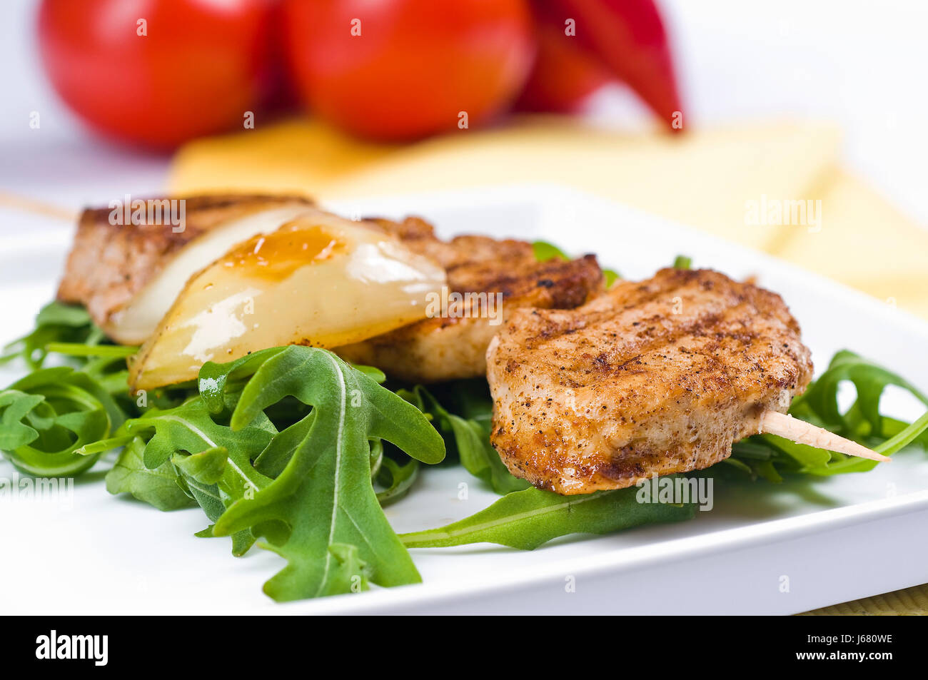 pork medallions on skewers with onions on rocket salad Stock Photo