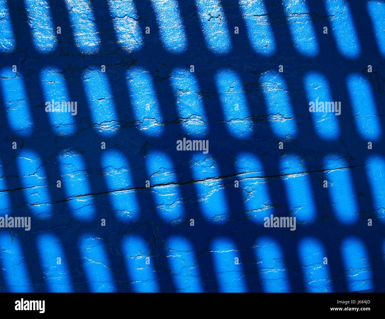 Blue board. Shadow from the grate Stock Photo