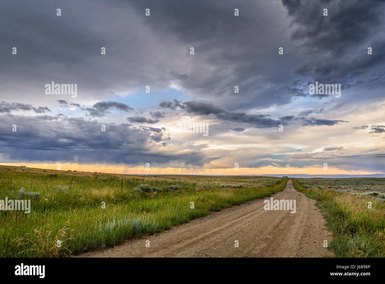 Road and sunset clouds on the sagebrush plateau between Red Lodge and Luther, Montana. Stock Photo