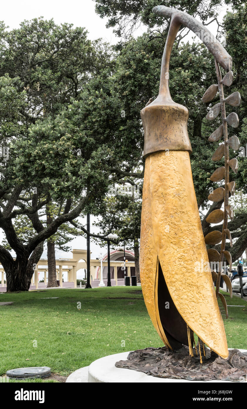 Napier, New Zealand - March 9, 2017: The Gold of the Kowhai statue by Paul Dibble at beach park and Tennyson street intersection. Green trees in back. Stock Photo
