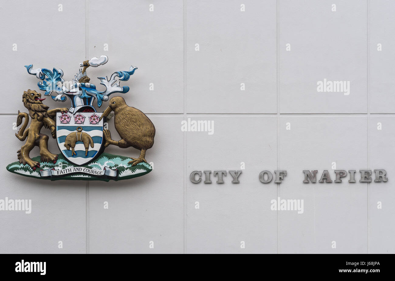 Napier, New Zealand - March 9, 2017: Closeup of colorful Coat of Arms and name of the city on the white wall of city hall. Stock Photo
