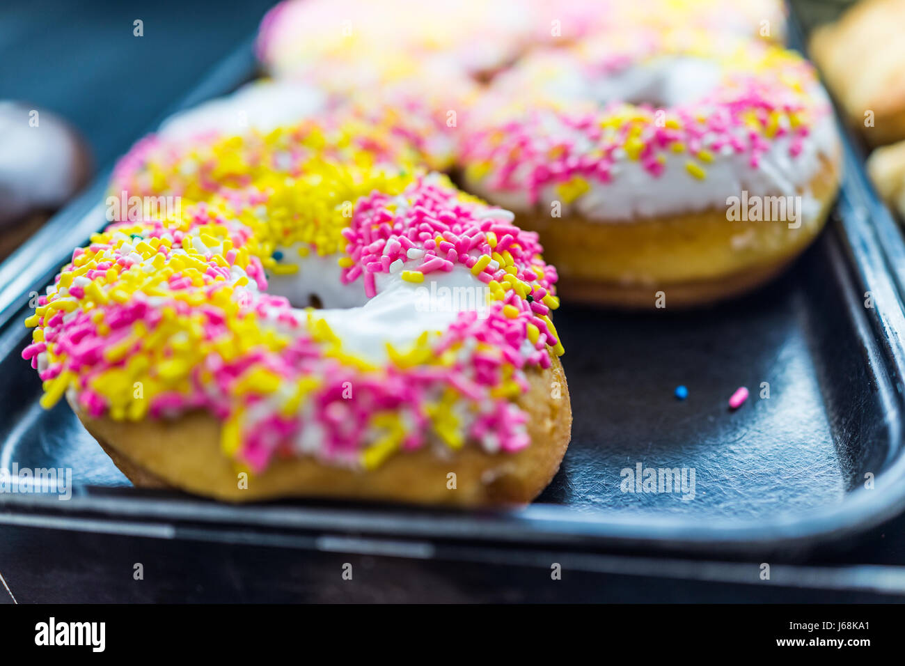 Donuts pink icing sprinkles closeup hires stock photography and images
