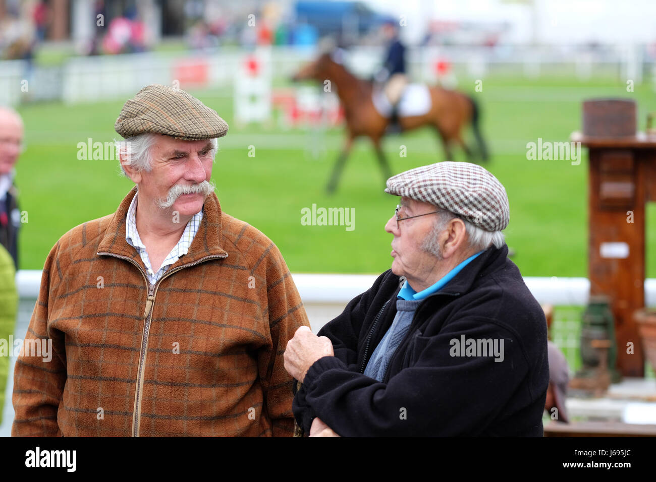 Royal Welsh Spring Festival, Builth Wells, Powys, Wales - May 2017 - Two farmers enjoy the chance to chat at the show jumping arena - the Royal Welsh Spring Festival. Credit: Steven May/Alamy Live News Stock Photo
