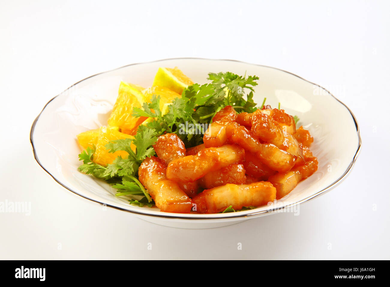 Sliced pork braised with oranges on white dish Stock Photo