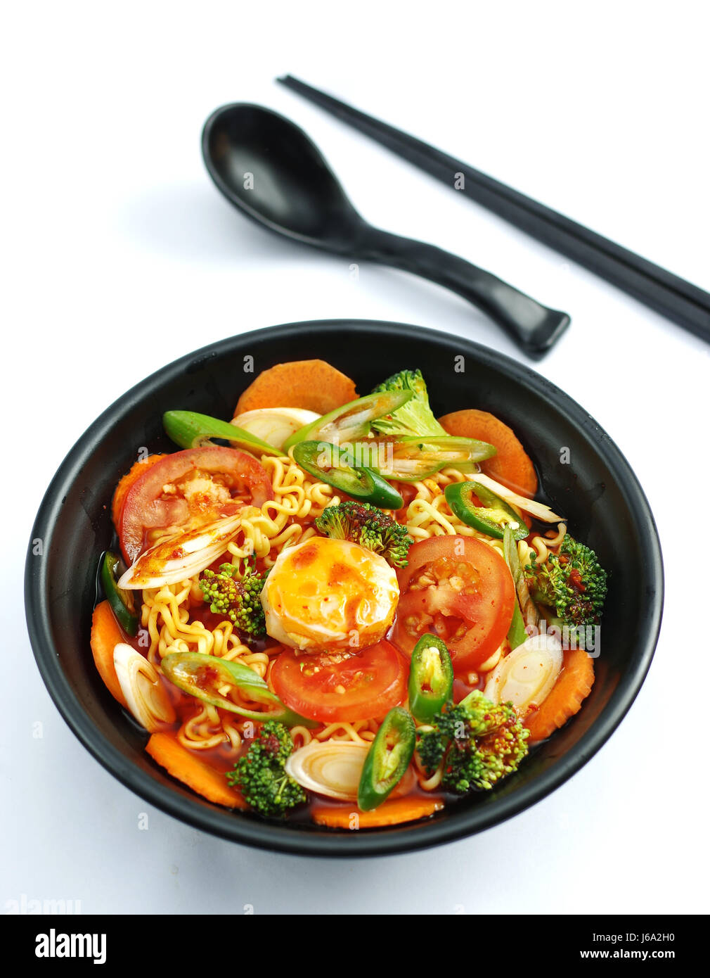 Hot chili ramen noodle with tofu and tomatoes in black stew Stock Photo