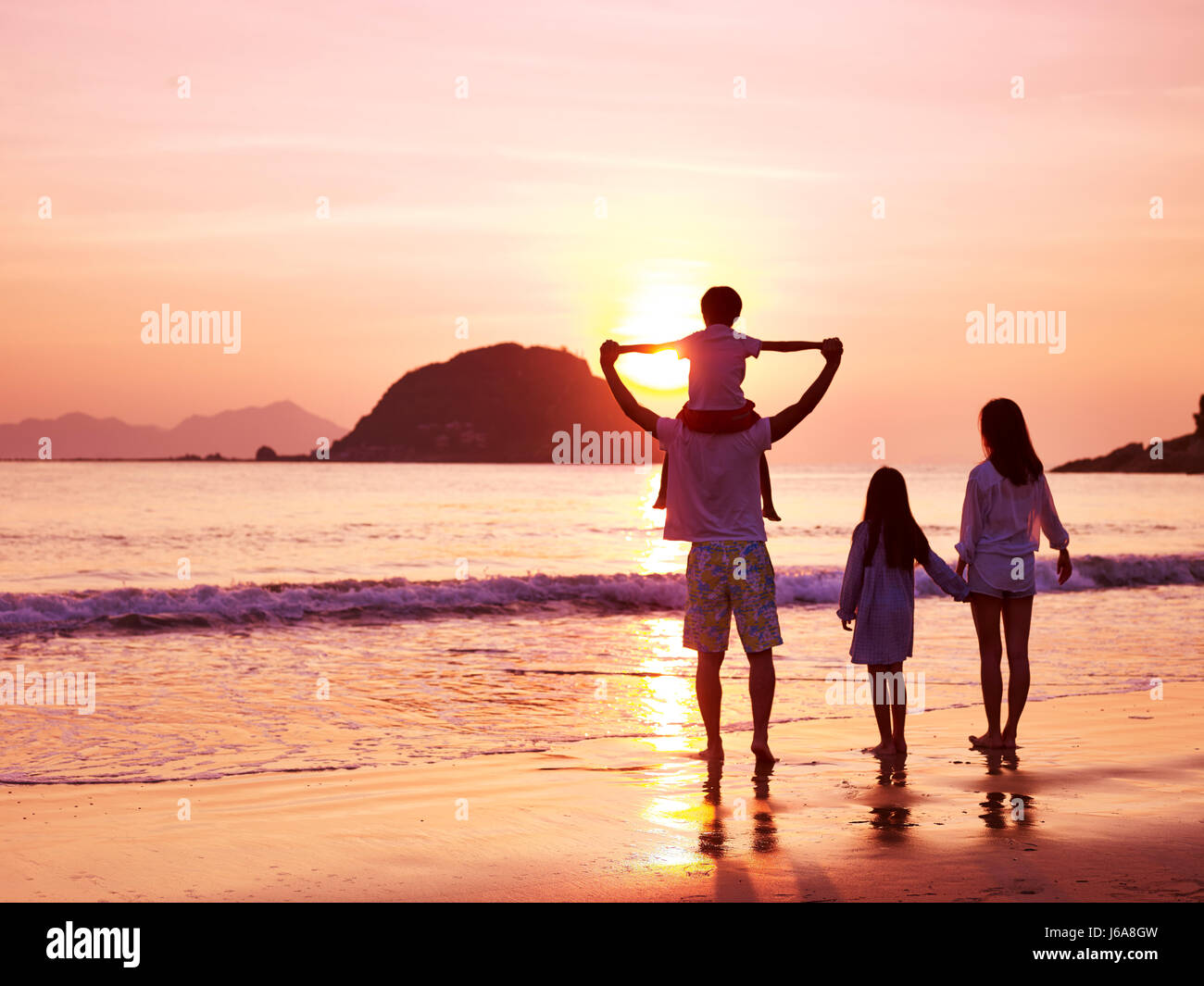 asian family standing on beach watching and enjoying the sunrise Stock ...
