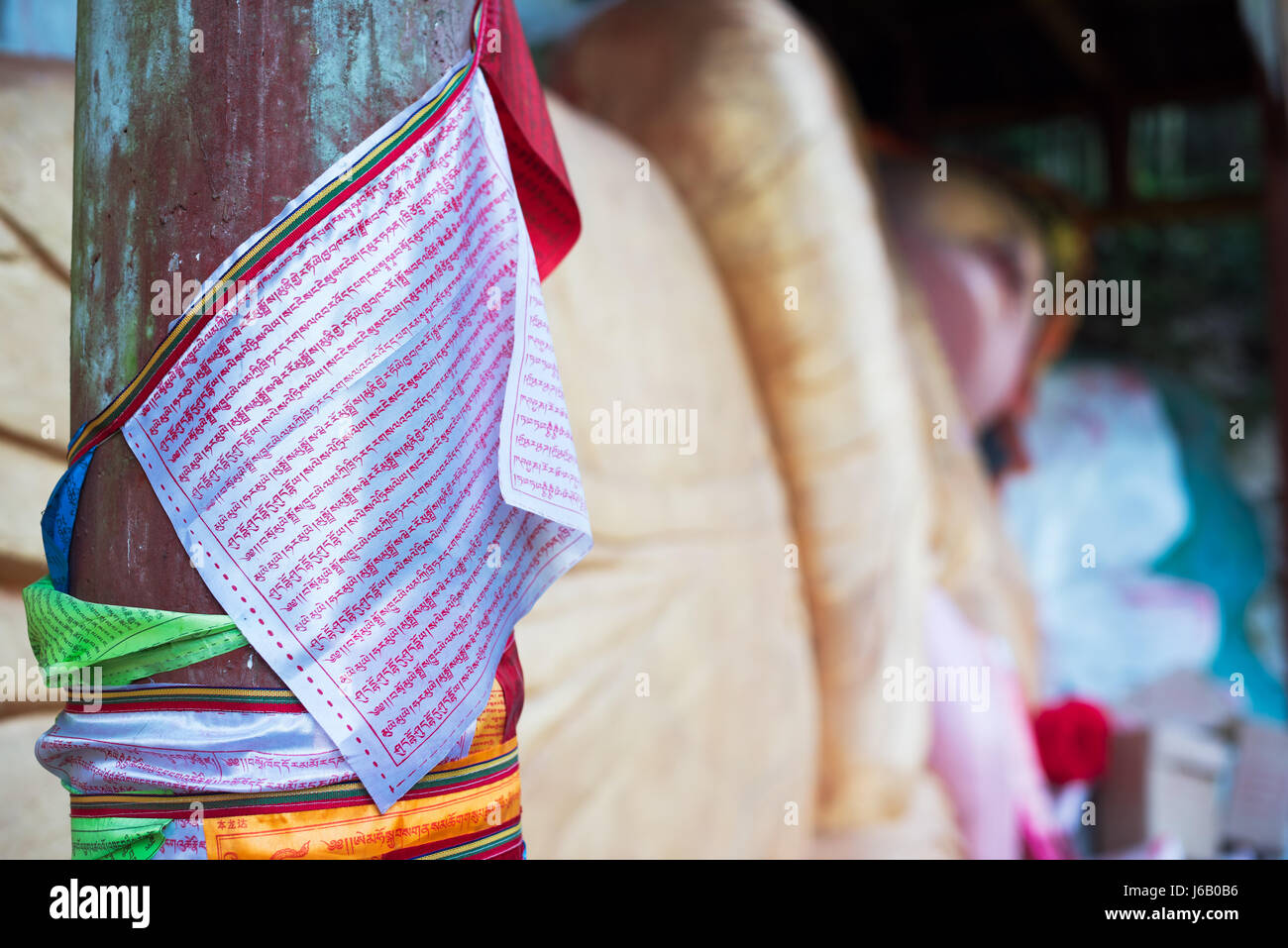 Hongya, Sichuan Province, China - Apr 29, 2017: Tibetan script on flags hanging near a lying buddha in Gaomiao temple Stock Photo