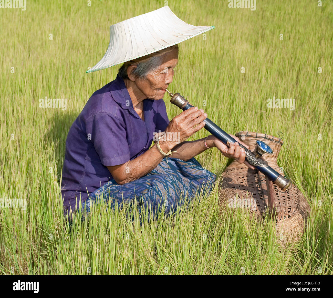 woman asia seniort smoker whiff smoke smoking opium woman culture relaxation Stock Photo
