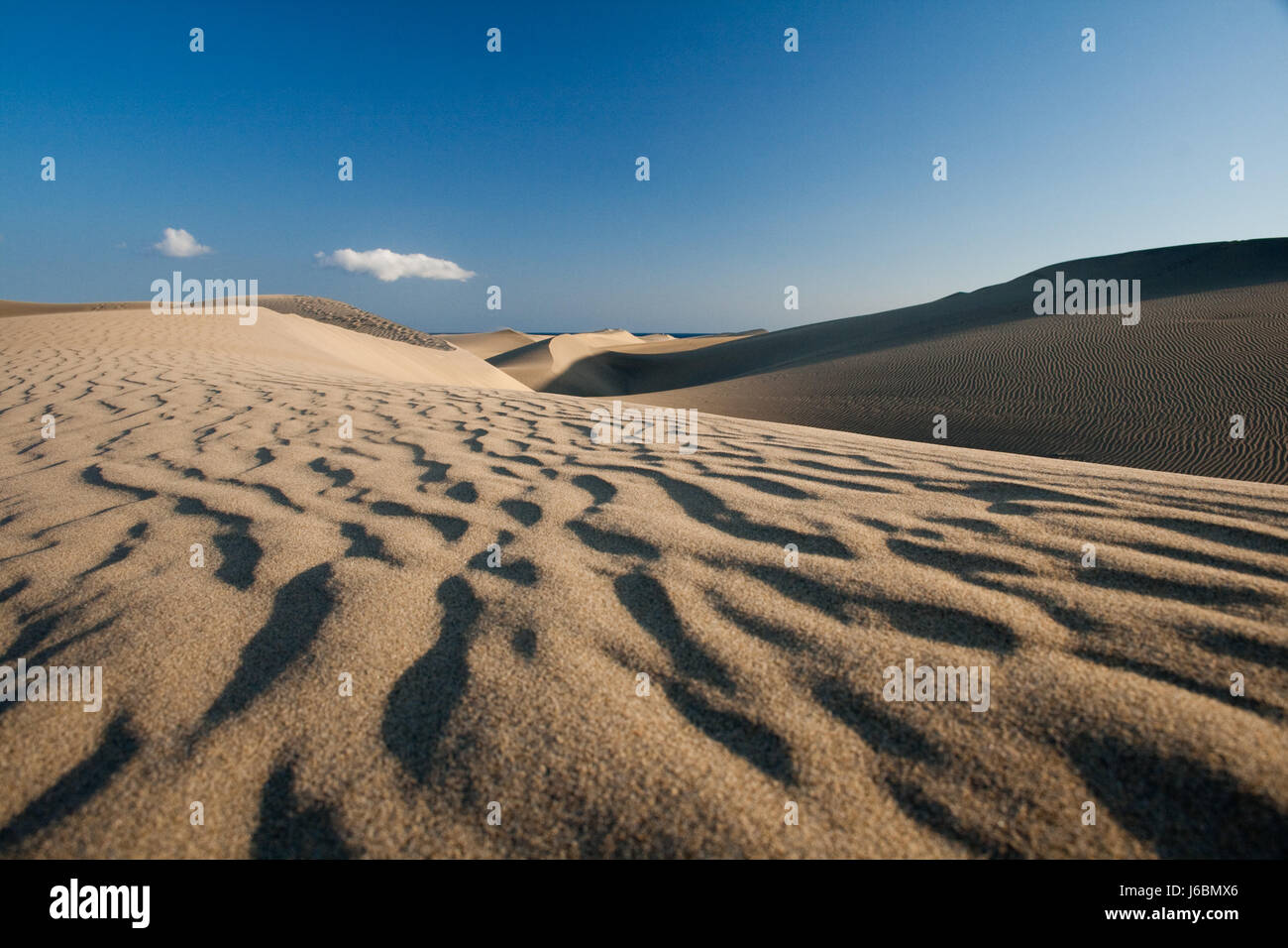 desert wasteland waves hot dunes dune sands sand blue travel hill holiday Stock Photo