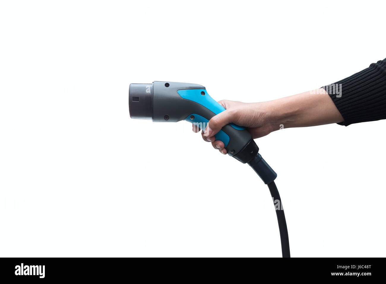 Hand holding Electric car charger on white background. Air pollution and reduce greenhouse gas emissions concept. Stock Photo