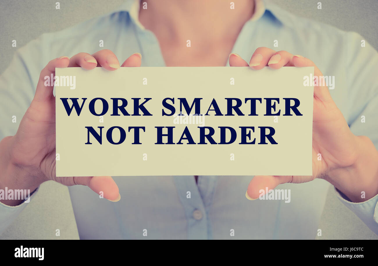 Work Smarter Not Harder Concept. Closeup retro style image business woman hands holding card with motivational message phrase text written on it isola Stock Photo