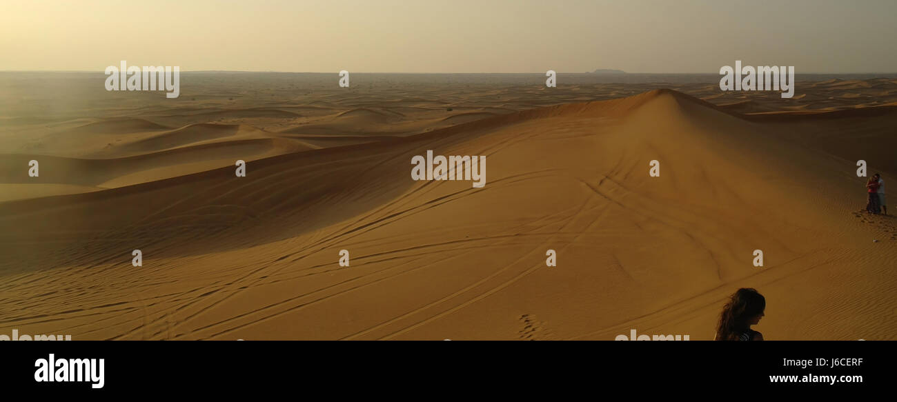 Evening view desert sand dune landscape viewpoint with three tourists, Alpha Tours Desert Safari, Dubai, United Arab Emirates Stock Photo