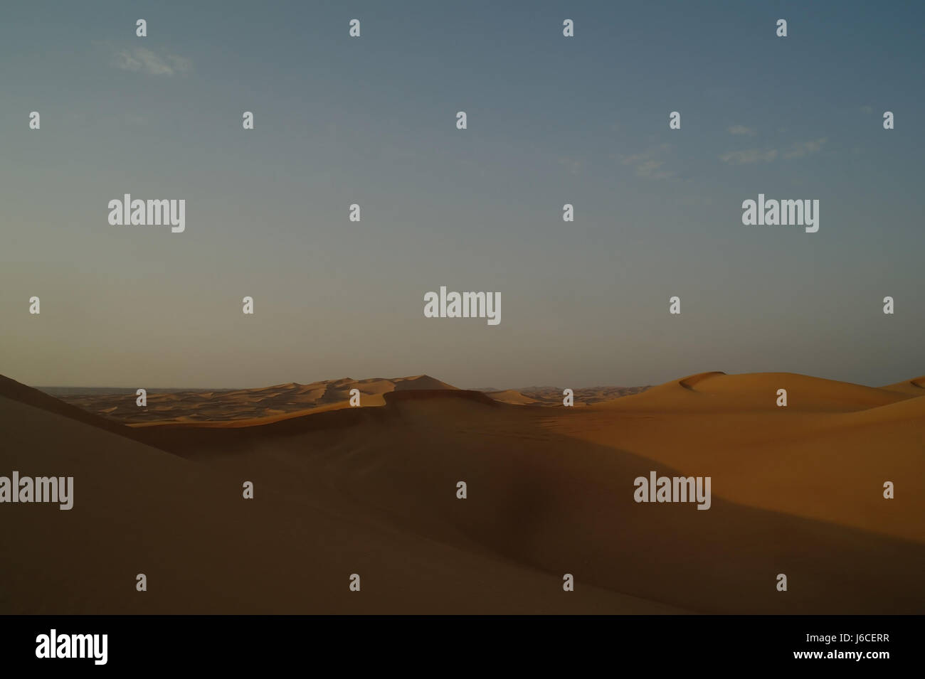 Blue sky view tall high yellow orange sand dunes desert landscape expanse, viewpoint en route to Alpha Tours Desert Camp, Dubai, United Arab Emirates Stock Photo