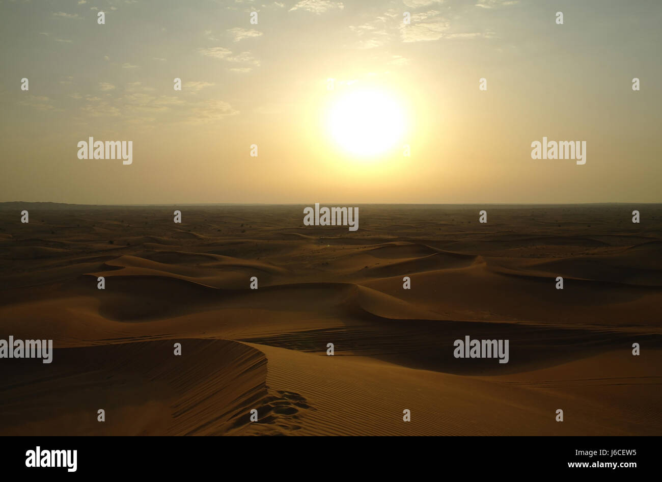 Sunset view over orange desert sand dunes expanse to level, wide horizon, Alpha Tours Desert Safari, Dubai, United Arab Emirates Stock Photo
