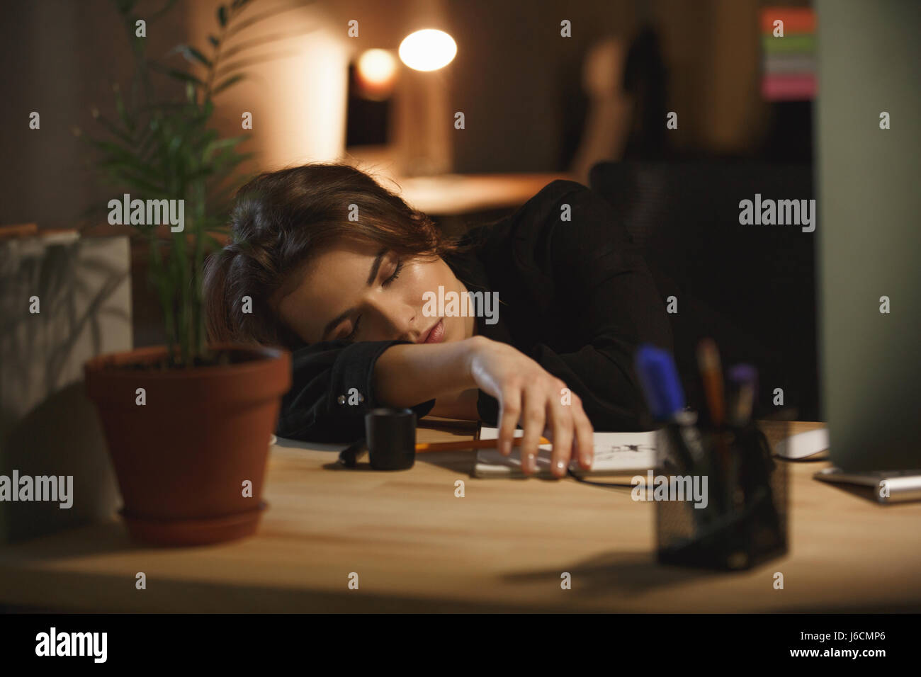 Young woman designer sleeping at workplace in office Stock Photo - Alamy