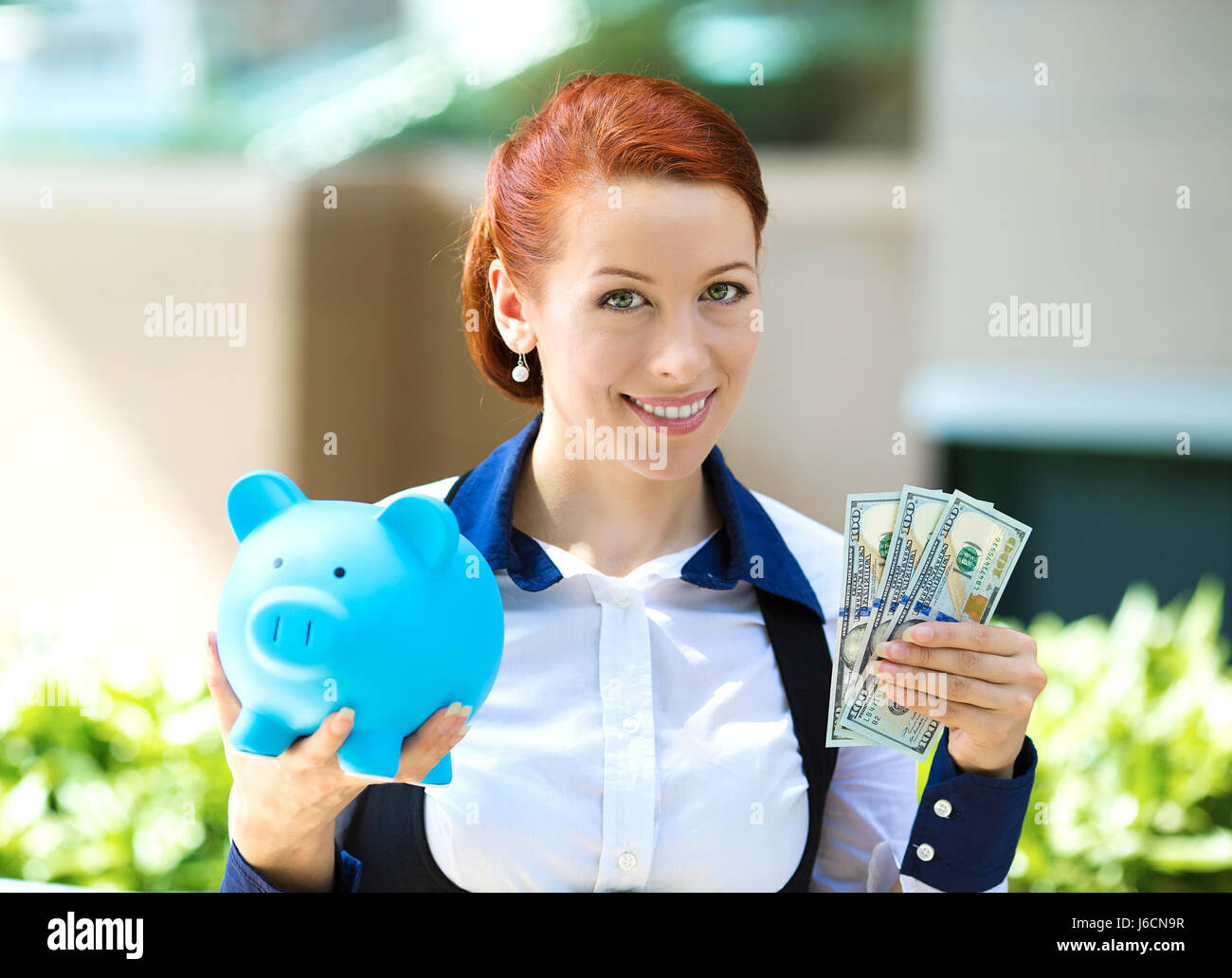 Closeup portrait happy business woman, bank employee holding piggy bank ...