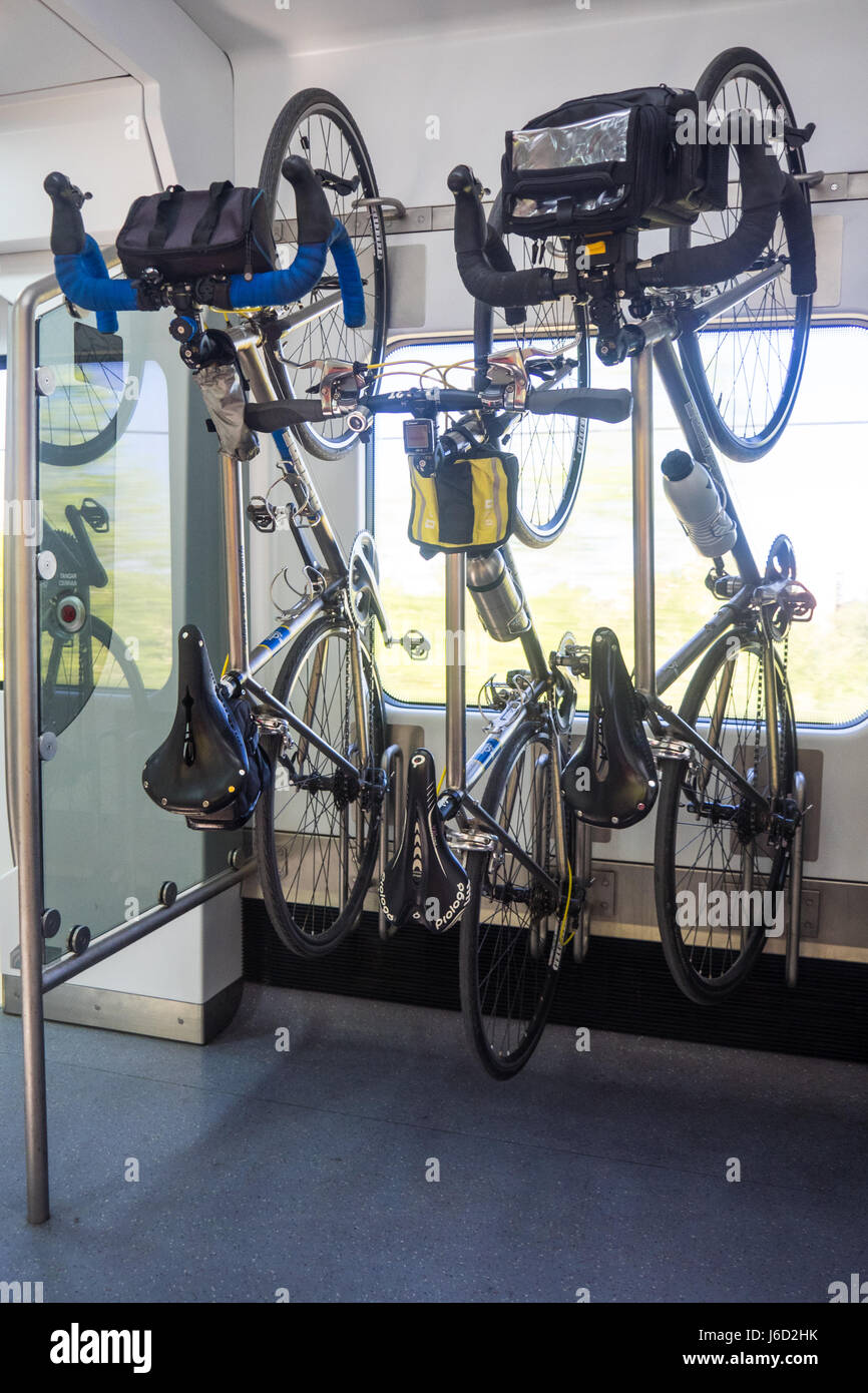 Three titanium Dekerf bicycles hanging on a bike rack in a train. Stock Photo