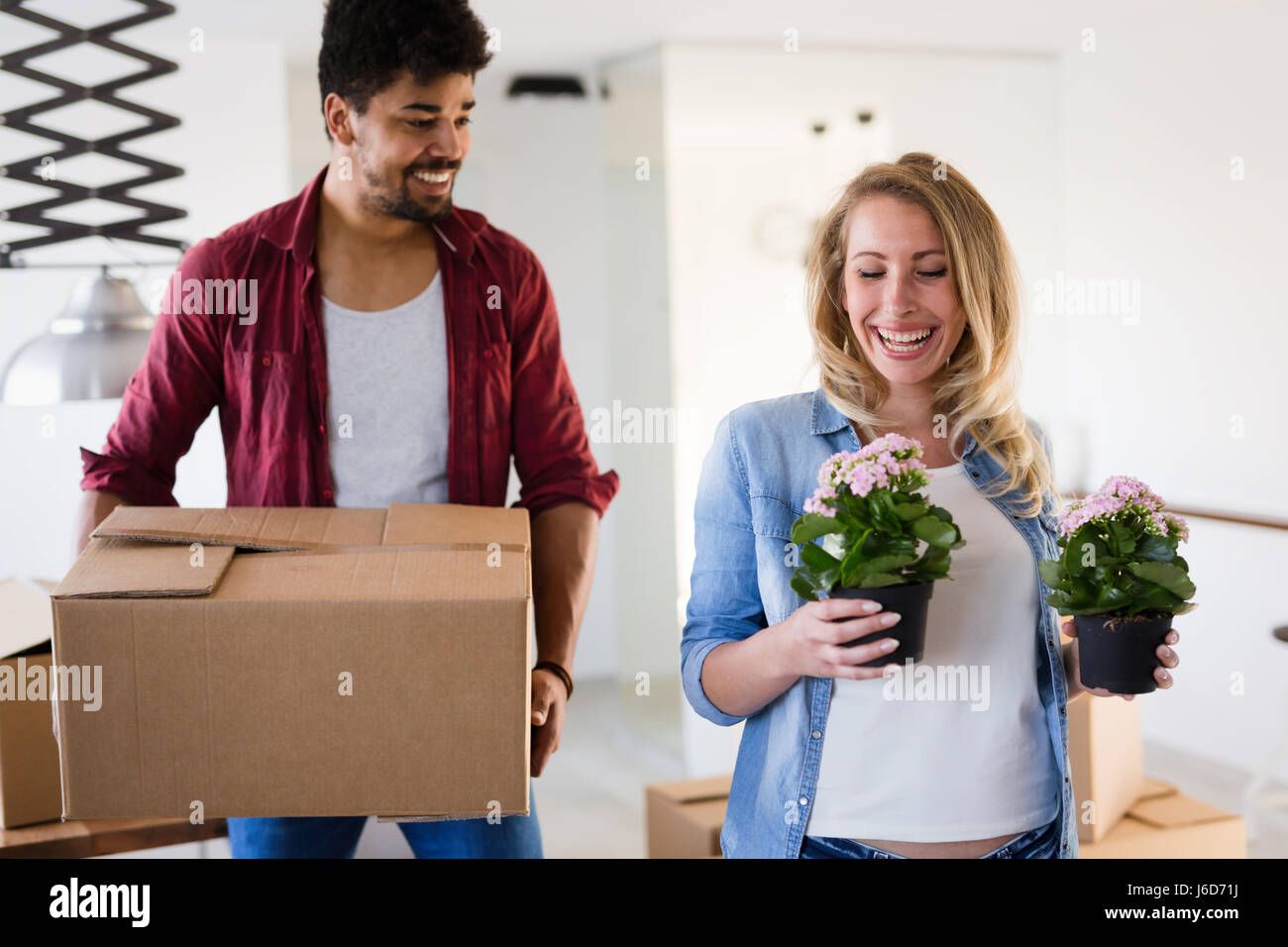 Young couple Moving in new home and unpacking carboard boxes Stock Photo