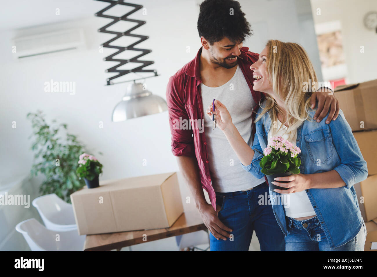 Young happy couple moving in new home and unpacking boxes Stock Photo ...