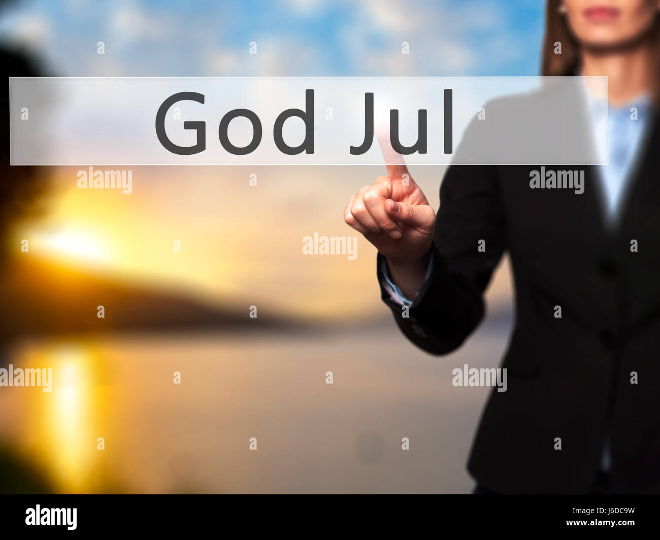 God Jul (Merry Christmas in Swedish) - Businesswoman hand pressing button on touch screen interface. Business, technology, internet concept. Stock Pho Stock Photo