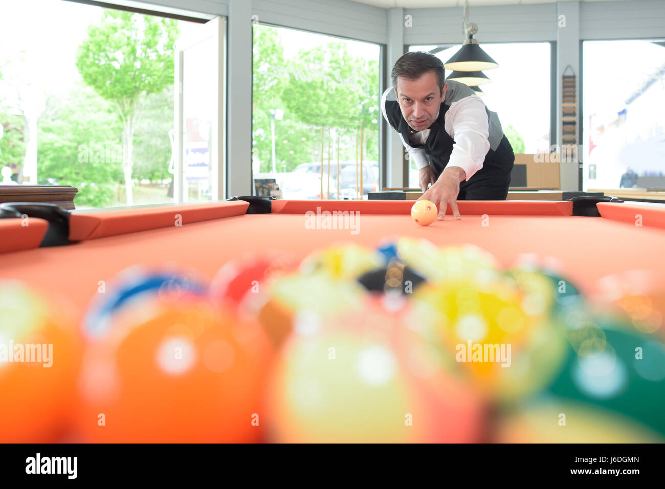 Man poised to hit cue ball on pool table Stock Photo Alamy