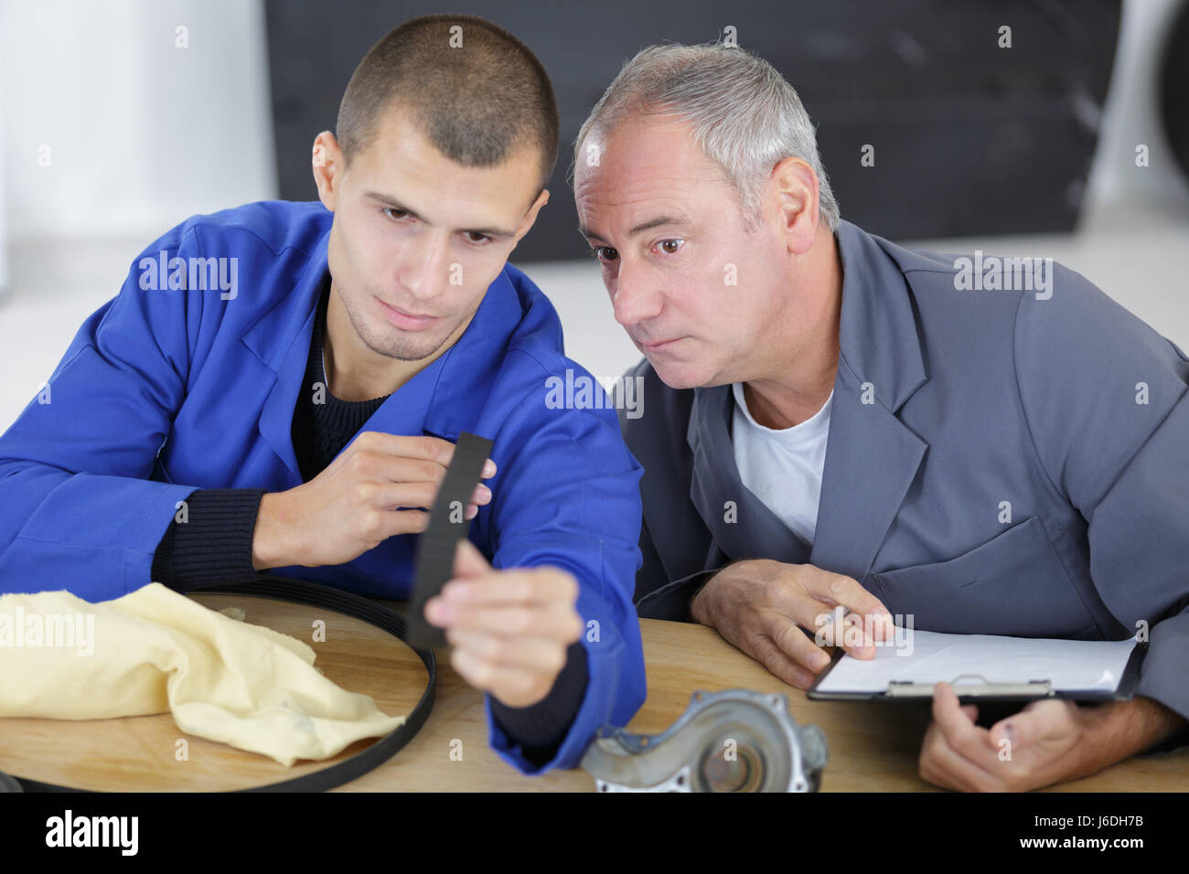 Young engineer looking at rubber belt Stock Photo